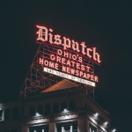 Night shot of lit sign reading "Dispatch: Ohio's Greatest Home Newspaper, 145 Years of Service"