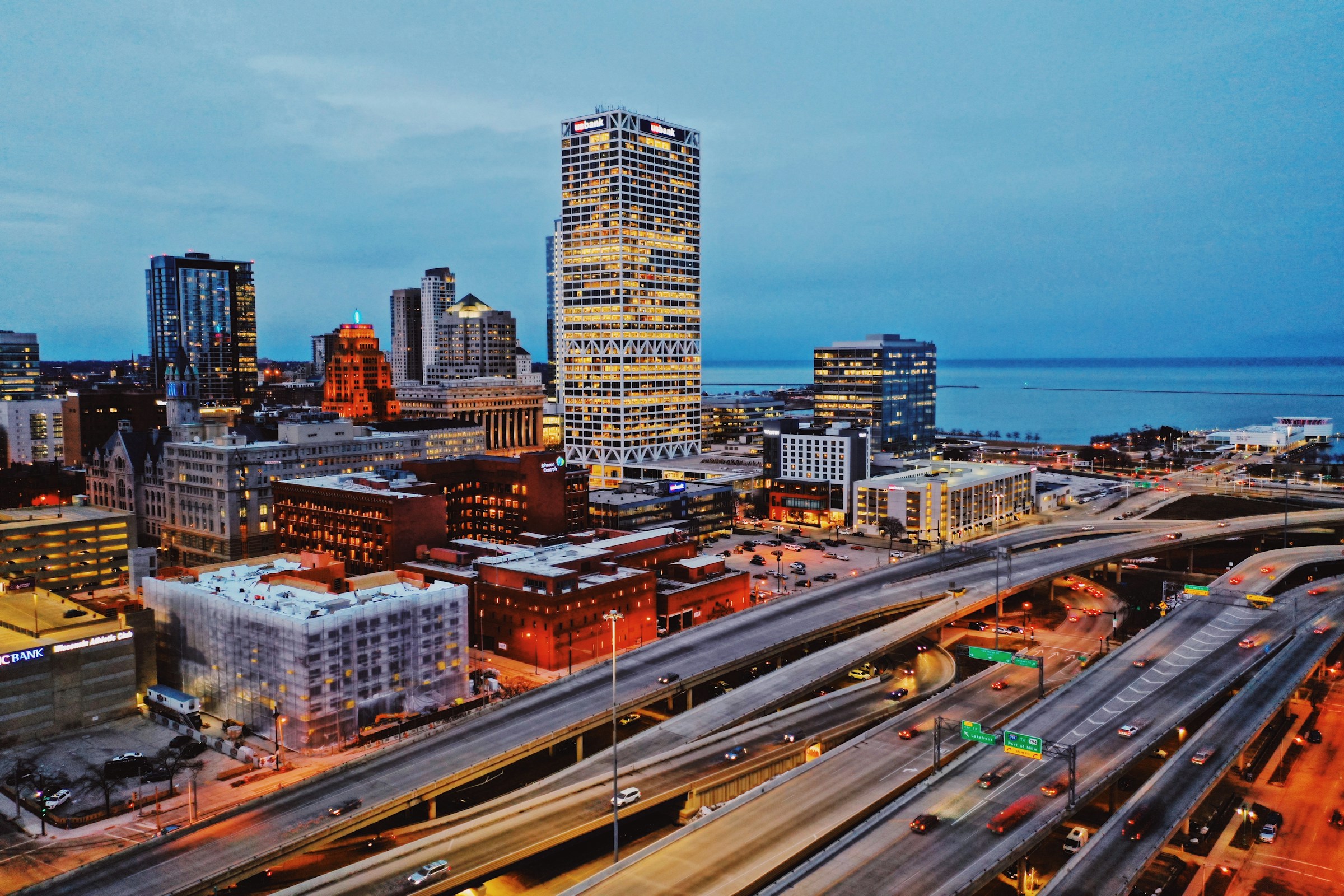 View of downtown Milwaukee, highways in foreground, Lake Michigan viewable in the background.